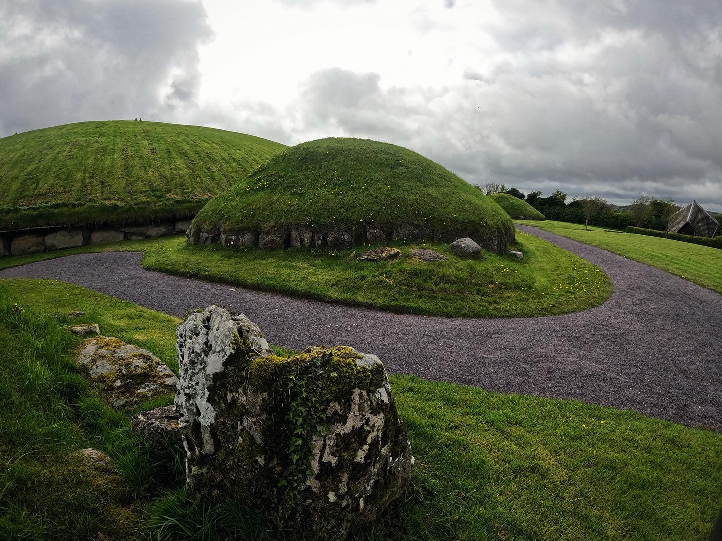 The Neolithic passage tomb mounds at Knowth, part of Brú na Bóinne in County Meath, with a decorated kerbstone in the foreground
