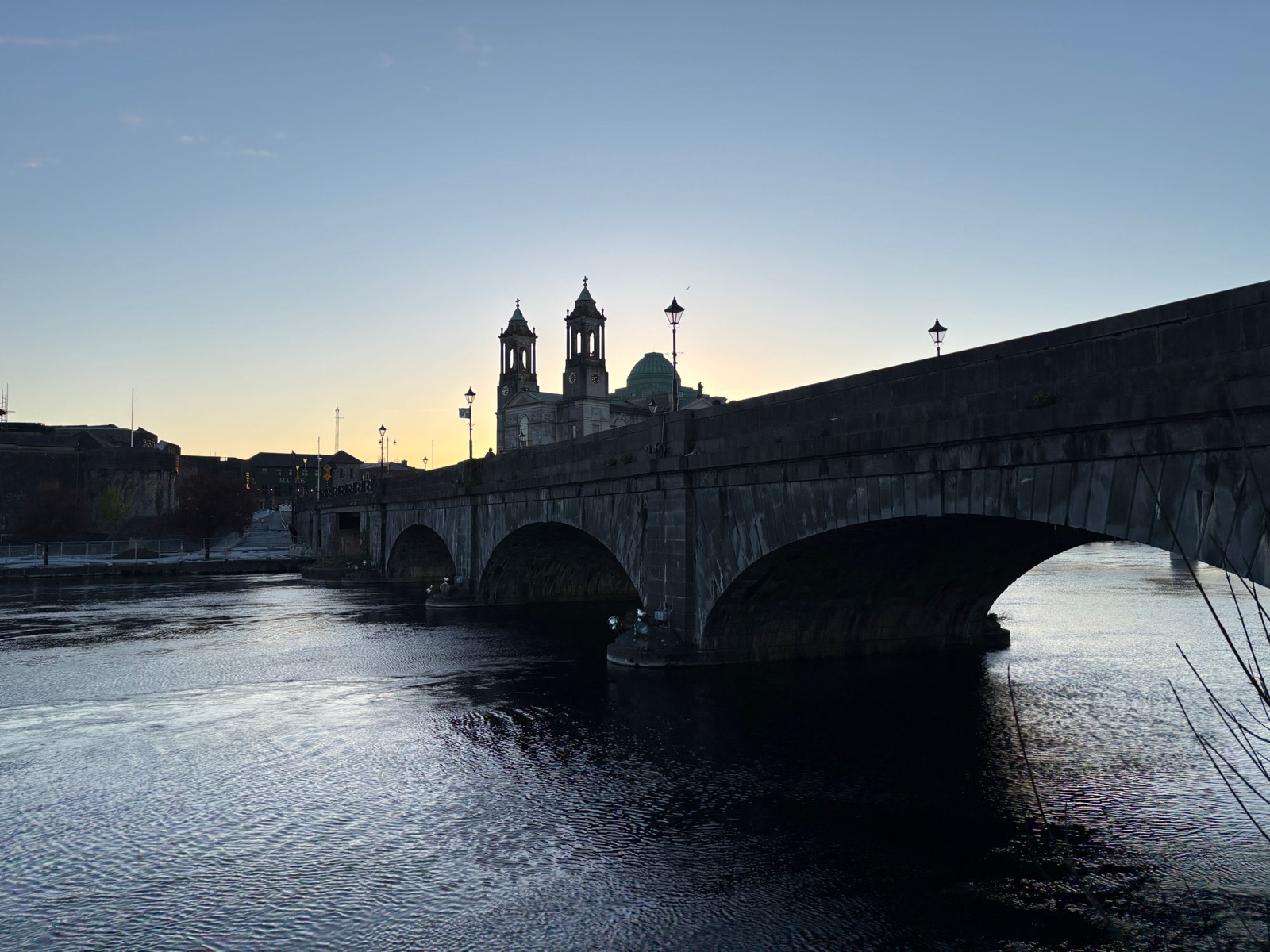 The town bridge over the River Shannon at Athlone, County Westmeath, with the twin towers of SS Peter and Paul's Church at sunset